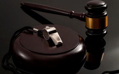 Whistleblower protection law and freedom of information legislation conceptual idea with metal whistle and wooden judge gavel on dark background
